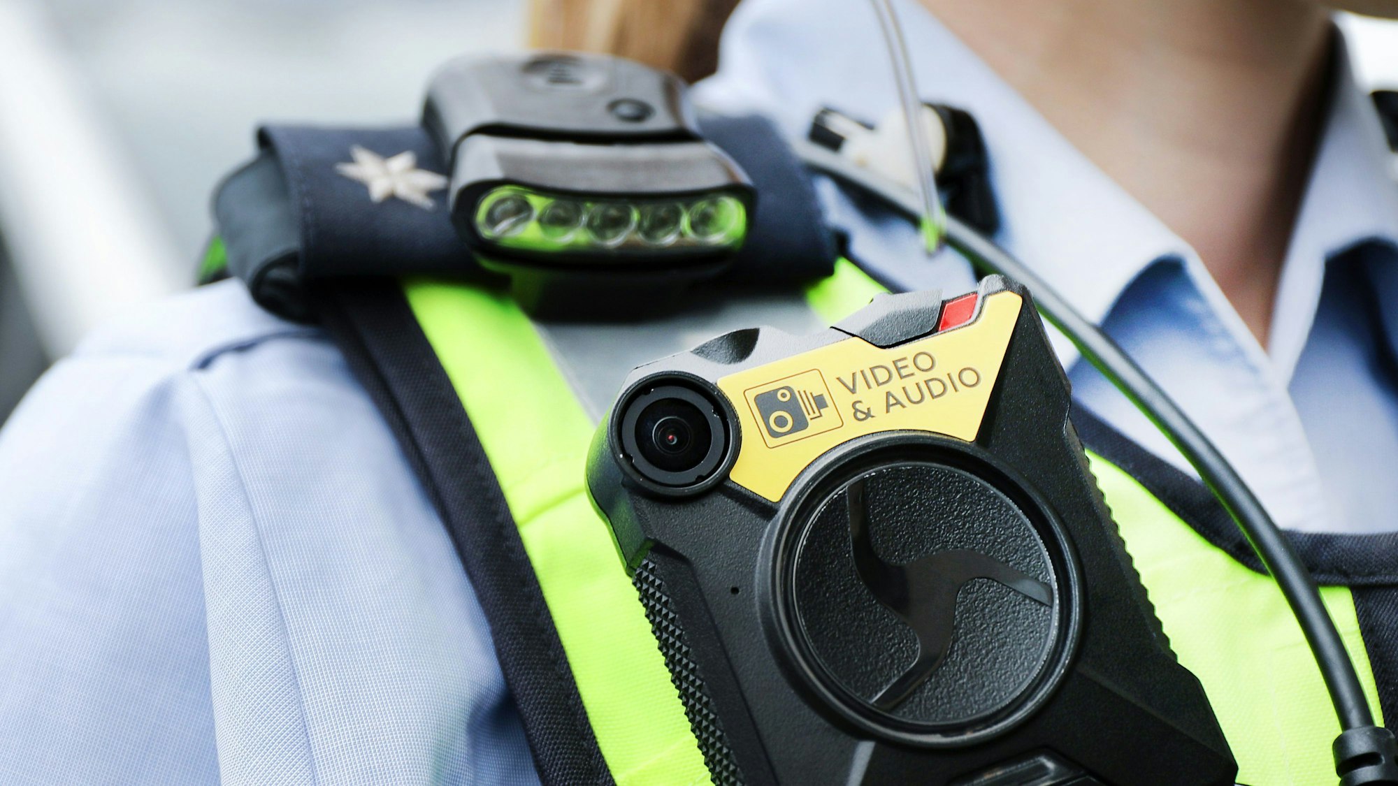 Eine Polizistin der Streifenpolizei führt eine Bodycam vor.