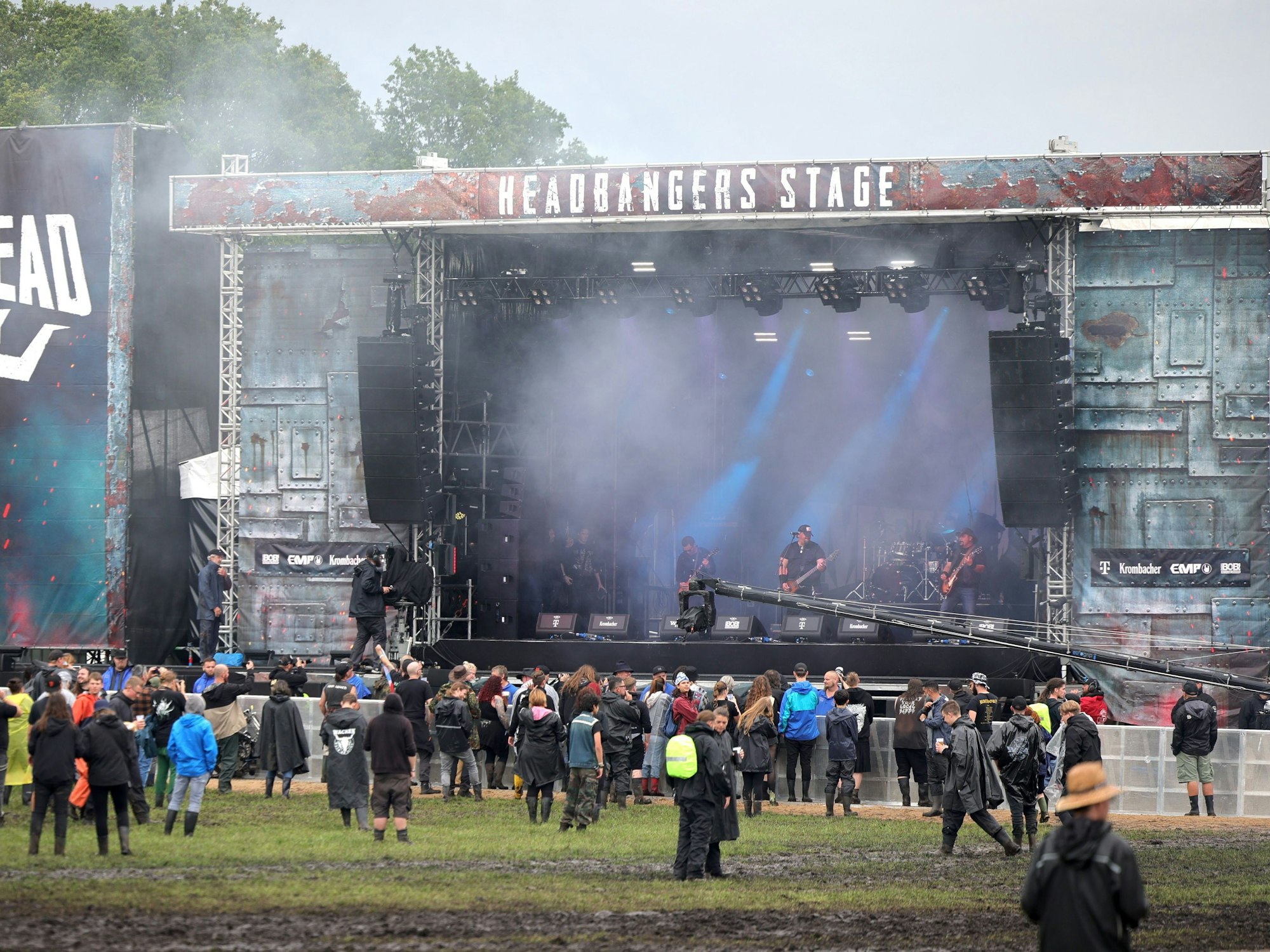 Metal-Fans freuen sich nach der Öffnung der Tore vor einer Bühne auf dem inneren Festivalgelände.