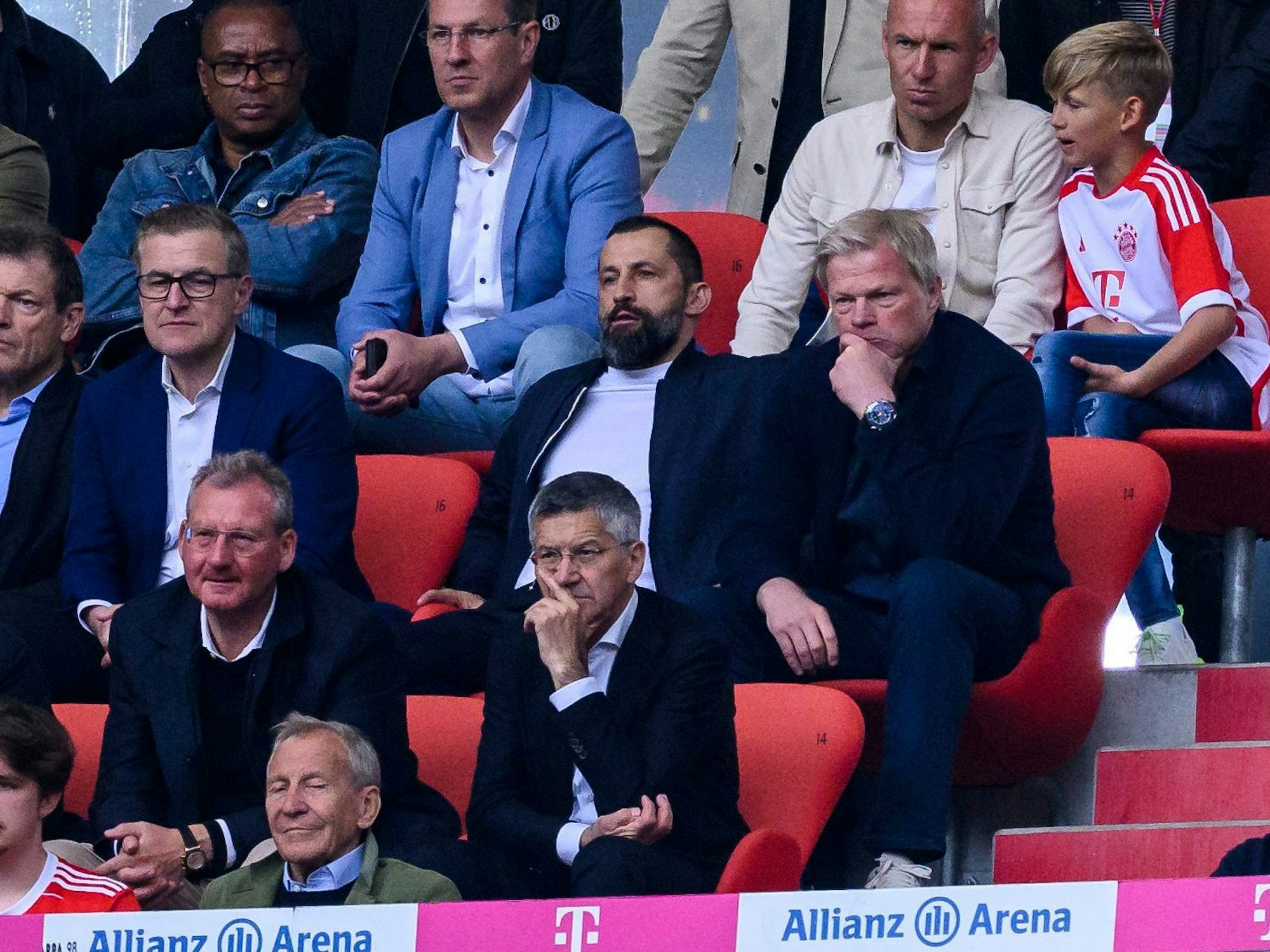 Münchens Sportvorstand Hasan Salihamidzic (M) und Münchens Vorstandsvorsitzender Oliver Kahn (r) sitzen auf der Tribüne. Links sitzt Finanzvorstand Jan-Christian Dreesen.
