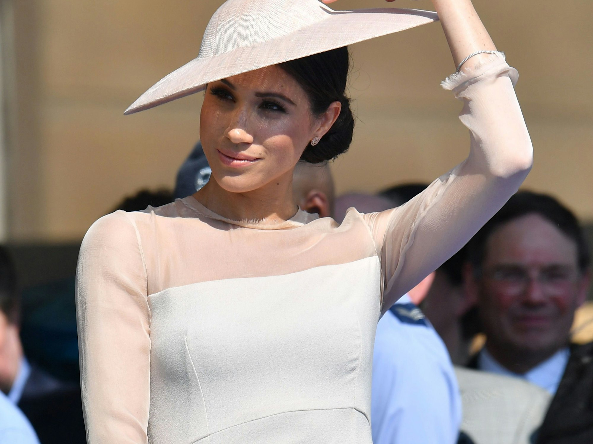 Herzogin Meghan mit ihrem knielangen Kleid samt Sonnenhutbeim Gartenfest im Buckingham Palace.