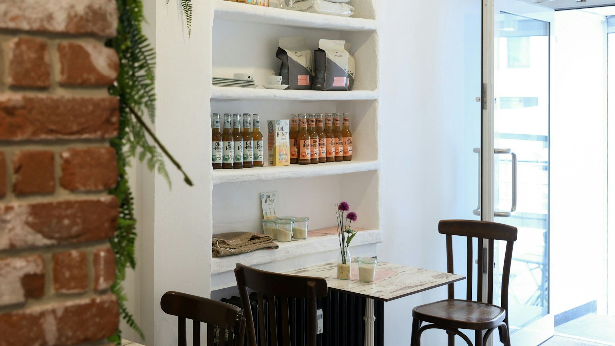 Blick ins Café mit kleinem Tisch und Mauerwerk an der Wand.
