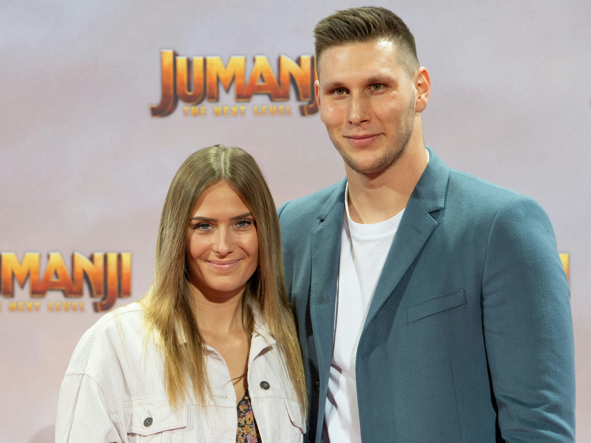 Melissa Halter und Niklas Süle stehen auf dem Roten Teppich bei der Deutschlandpremiere des Filmes JUMANJI