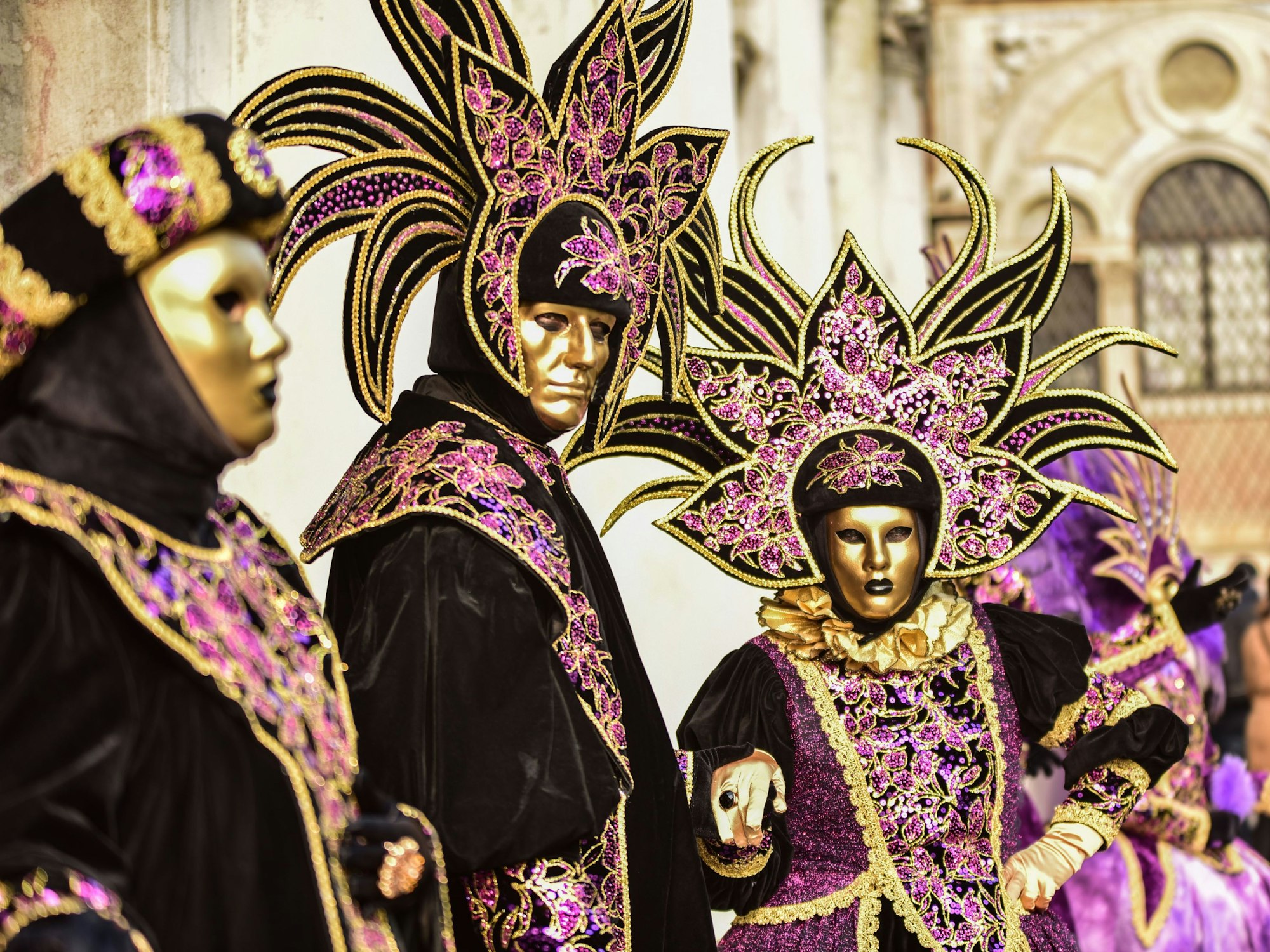 Personen mit verzierten Masken beim Karneval in Venedig.