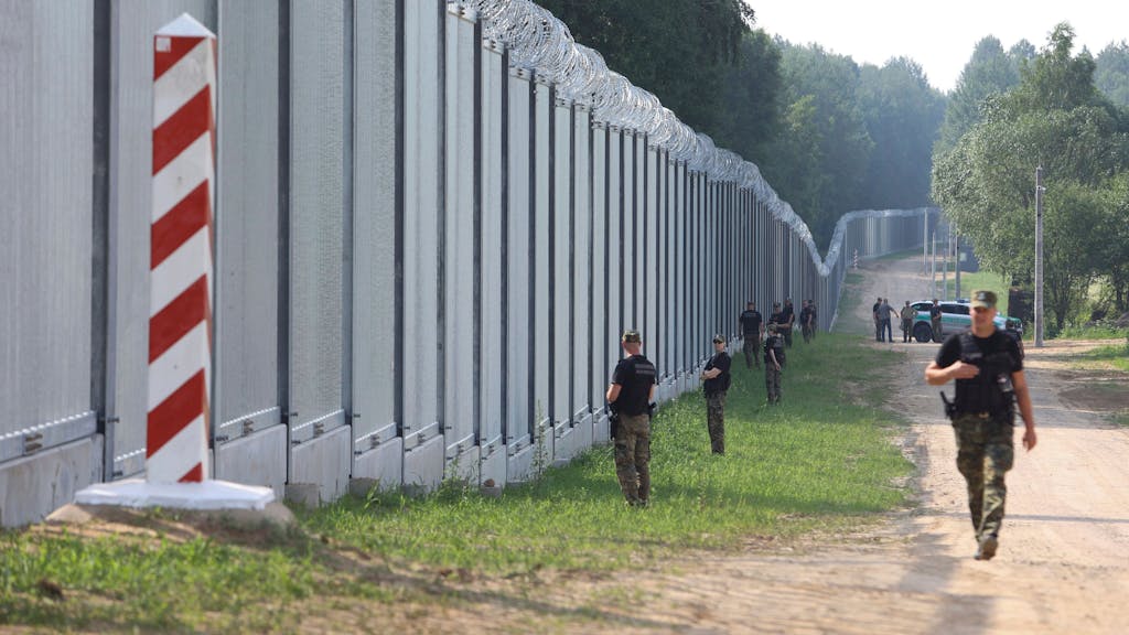 Polnische Grenzschützer patrouillieren im Bereich einer neu errichteten Metallmauer an der Grenze zwischen Polen und Belarus am 30. Juni 2022.