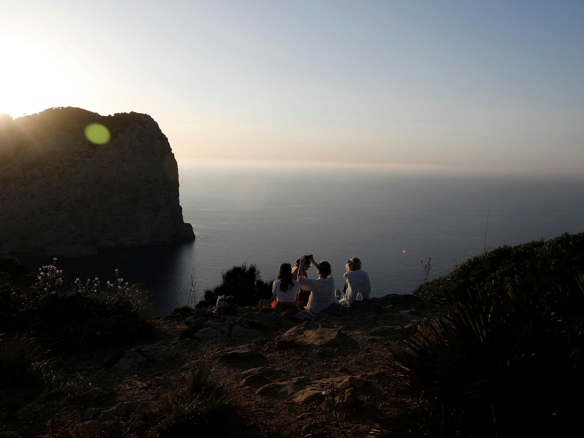 Eine Gruppe von Touristen nimmt einen Drink am Cap de Formentor in der Serra de Tramuntana, dem nördlichsten Teil der Insel Mallorca und einem der touristischsten Orte.