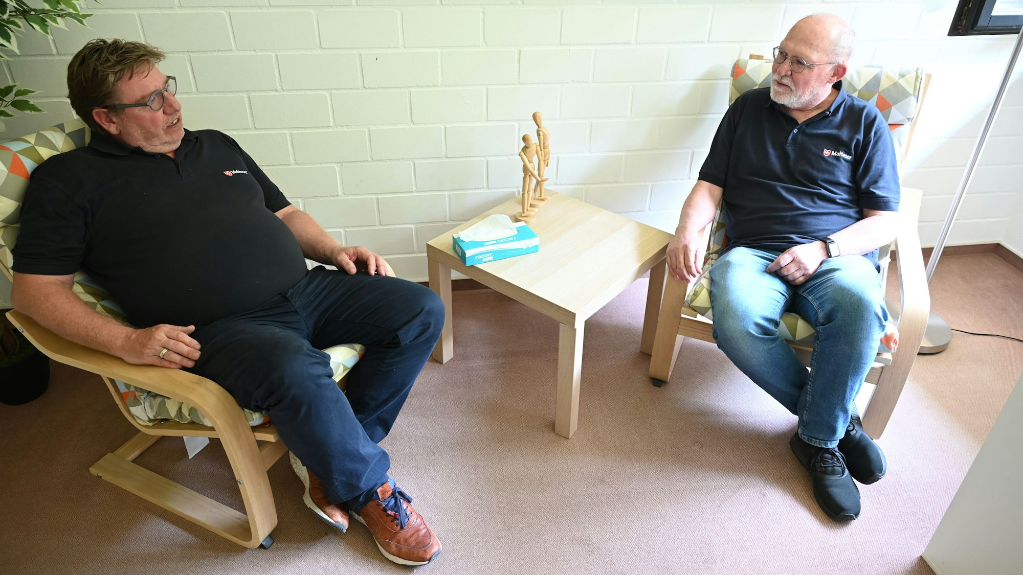 Frank C. Waldschmidt (l.) und Gerd Sebastian sitzen sich in Sesseln gegenüber und reden miteinander. Beide kümmern sich in Gemünd um die psychologische Betreuung Flutbetroffener.