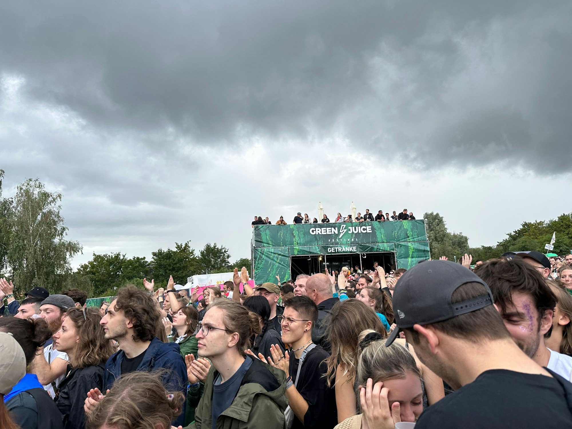Eine große Menschenmasse steht vor der Bühne des Green Juice Festivals.