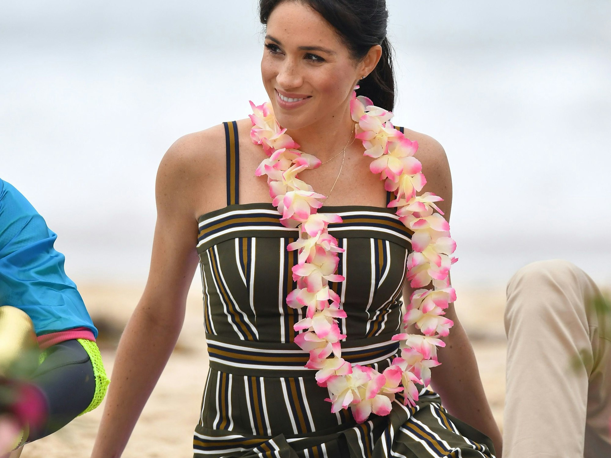 Meghan, Herzogin von Sussex, sitzt am Strand von Bondi und trägt eine Blumenkette.