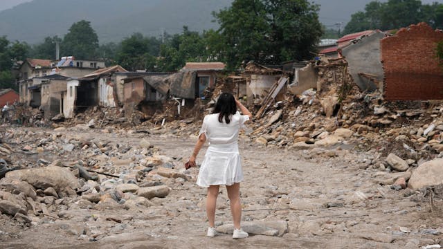 Zerstörung nach Flut in China: Eine Frau sucht nach den Überresten ihres Hauses, nachdem das Hochwasser das Dorf Nanxinfang nahe Peking erfasst hat.