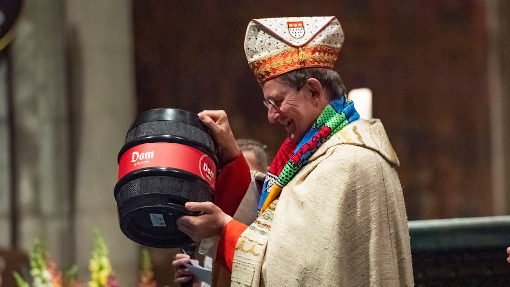 Kardinal Woelki segnet ein Pittermännchen im Kölner Dom.