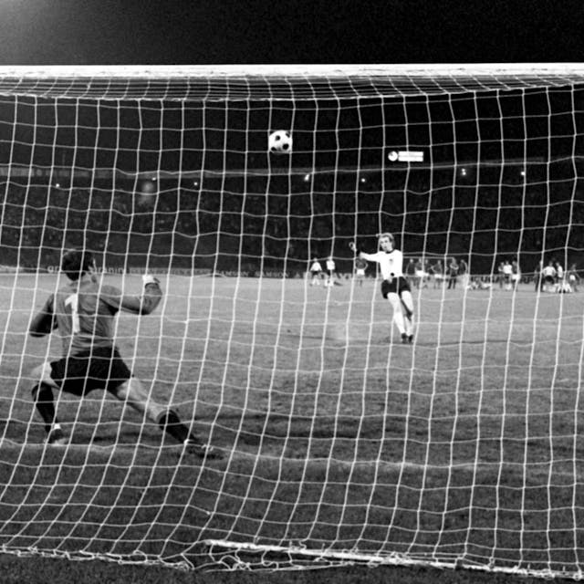 Auf dem Foto ist der verhängnisvolle Schuss im Elfmeter-Duell am 20. Juni 1976 in Belgrad im Europameisterschaftsfinale zwischen der deutschen Fußballnationalmannschaft und der CSSR zu sehen: Tschechoslowakei-Torhüter Ivo Viktor schaut gebannt zu, wie der deutsche Mittelfeldspieler Uli Hoeneß den Ball über die Latte schießt.