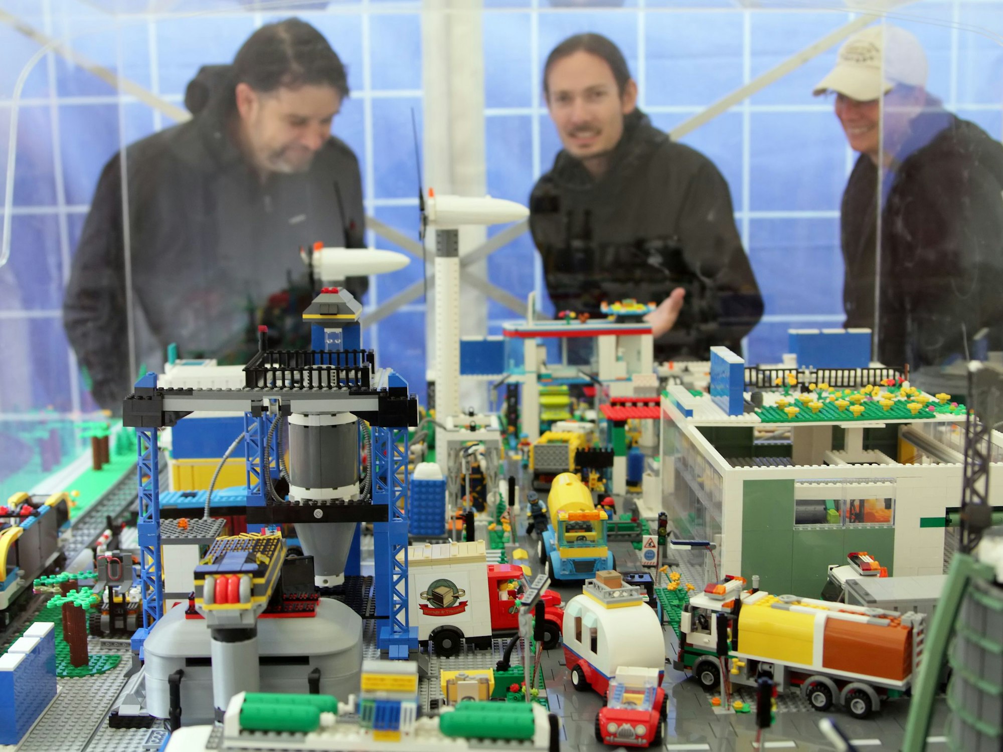 Menschen bestaunen eine aus Legosteinen gebaute Fabrik.