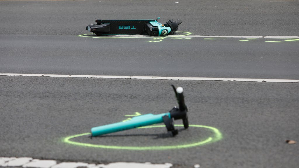 Ein zerstörter E-Scooter liegt nach einem Unfall auf der Straße.