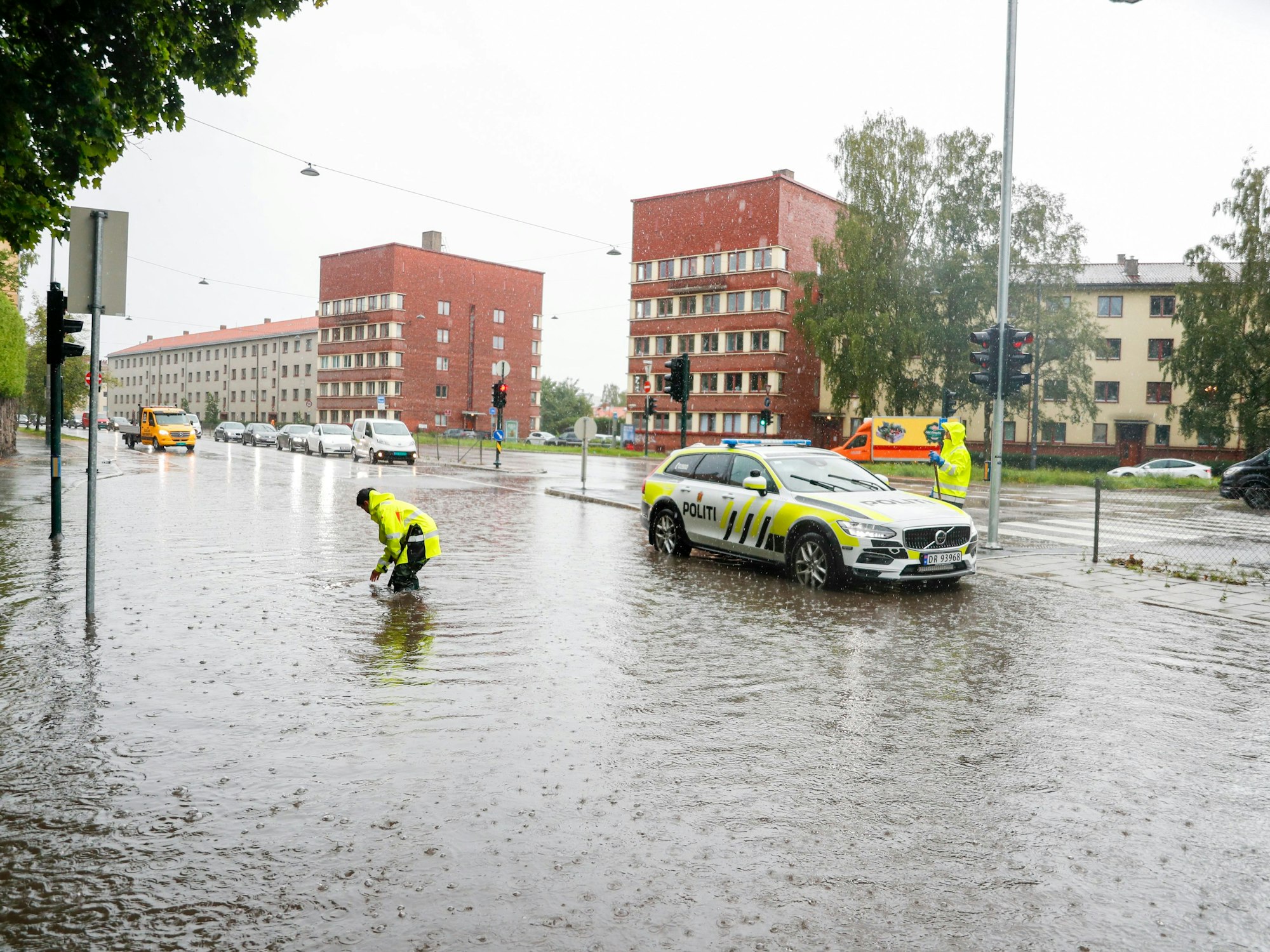 Polizisten öffnen am 7. August 2023 die Abwasserkanäle auf Straßen in Oslo während eines aufziehenden Unwetters, das in Skandinavien zu Überschwemmungen, Bränden und Wasserschäden geführt hat.