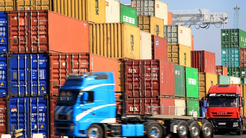 Am Hafen in Duisburg werden Container auf Lkw verladen.