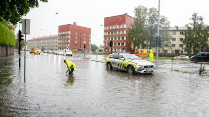 Oslo: Polizisten öffnen die Abwasserkanäle auf Straßen während eines aufziehenden Unwetters, das in Skandinavien zu Überschwemmungen, Bränden und Wasserschäden geführt hat