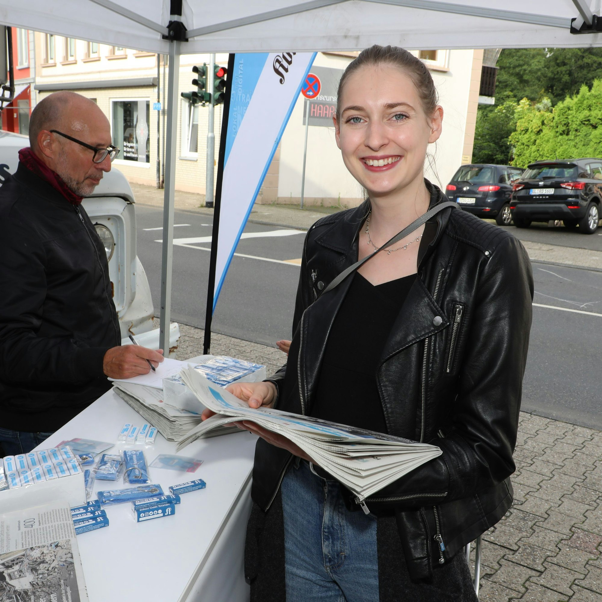 Henrike Weins schaut in eine Zeitung am Stand der Sommertour-Lokalredaktion in Hoffnungsthal.