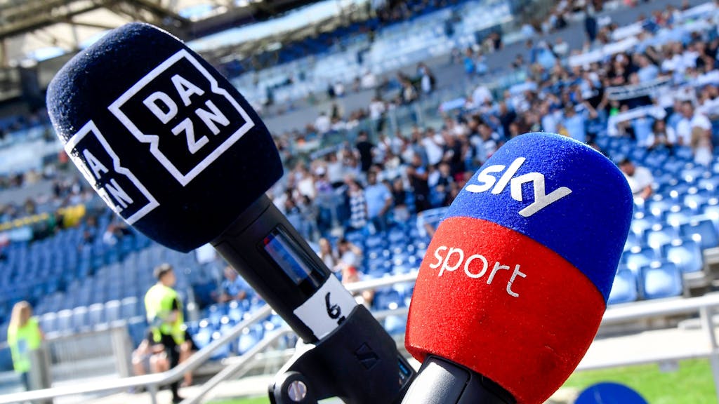Die Logos der Streaming-Anbieter Sky und DAZN sind auf Mikrofonen für eine Fußball-Übertragung zu sehen