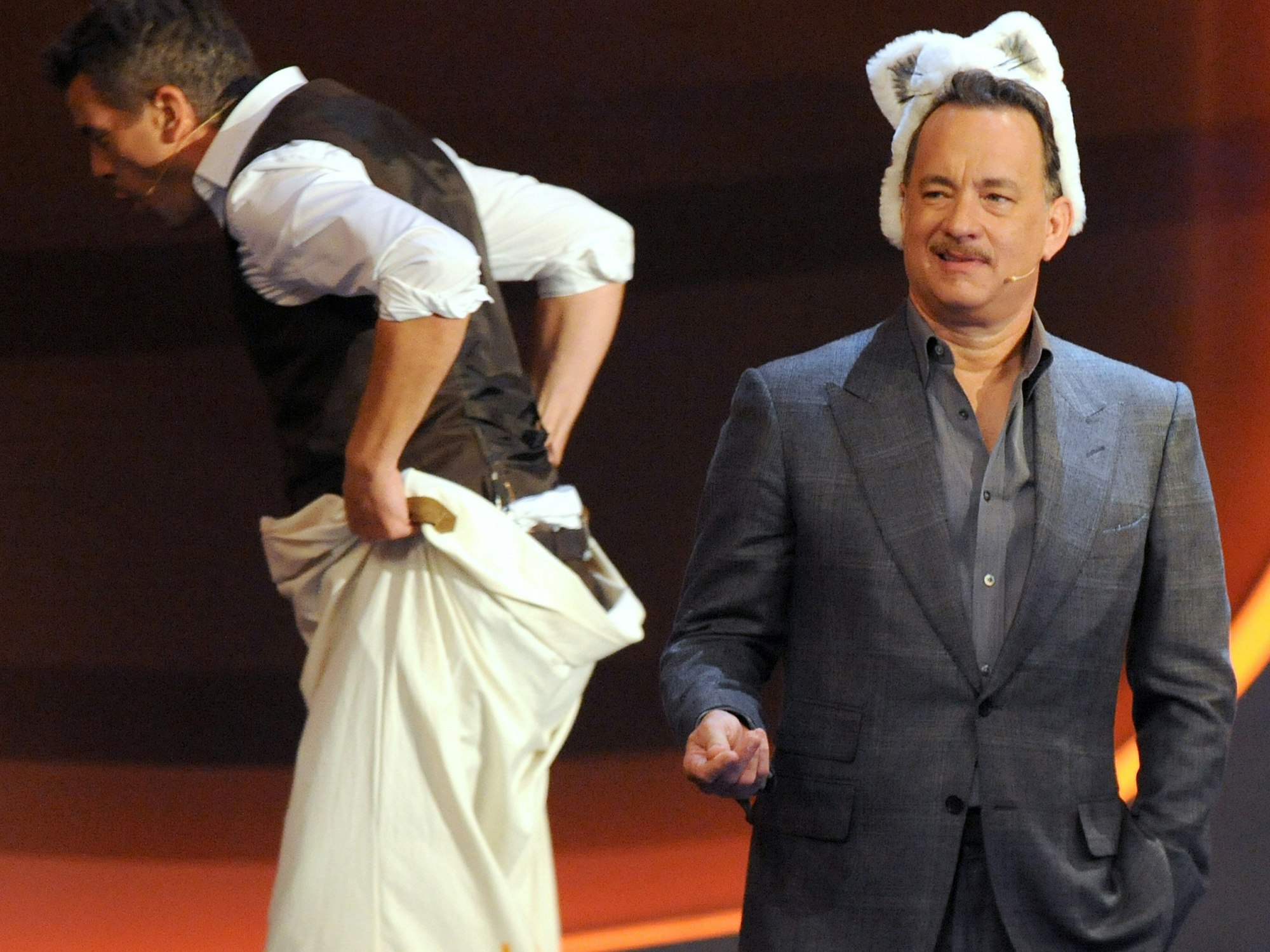 Schauspieler Tom Hanks (r) stellt am 03.11.2012 den Wendepunkt beim Sackhüpfen mit Moderator Markus Lanz in der ZDF-Livesendung "Wetten dass..?" aus Bremen da.