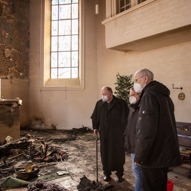 Drei Männer stehen in der durch ein Feuer völlig zerstörten Pfarrkirche Kreuzerhöhung in Wissen an der Sieg.&nbsp;