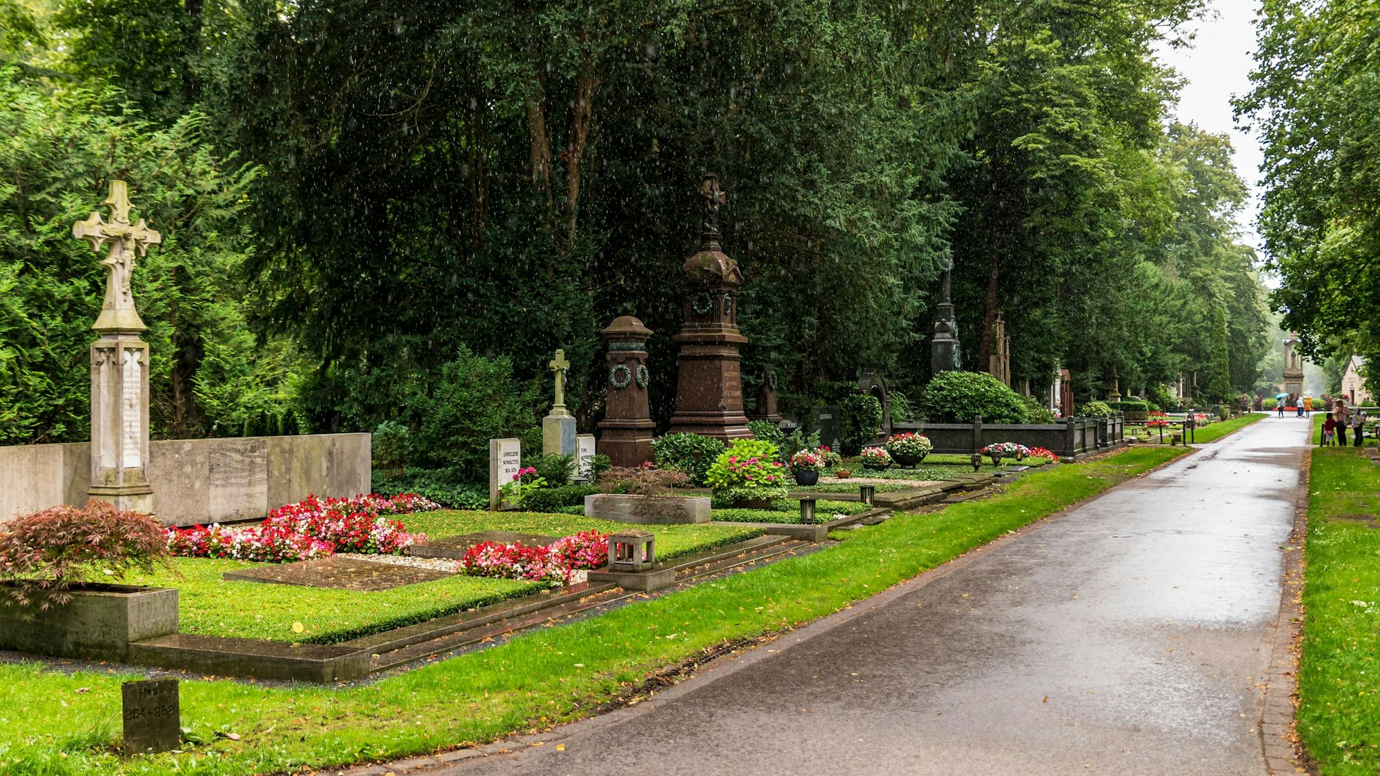 Der Melaten-Friedhof in Köln. Auf der linken Seite stehen Gräber.