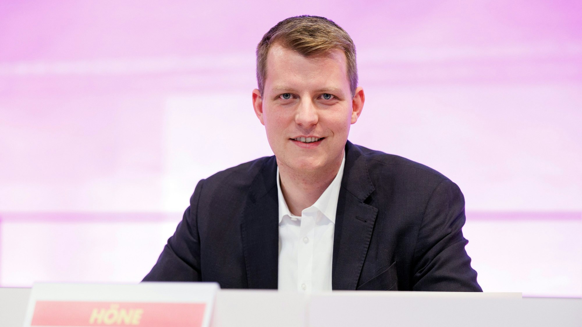 Henning Höne, Fraktionsvorsitzender der FDP im NRW-Landtag, sitzt an einem Pult. Sein Namensschild ist zu sehen.