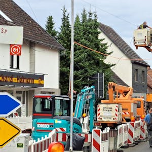 Bauarbeiter arbeiten auf der teilweise gesperrten Bensberger Straße (L 136) in Overath-Heiligenhaus.