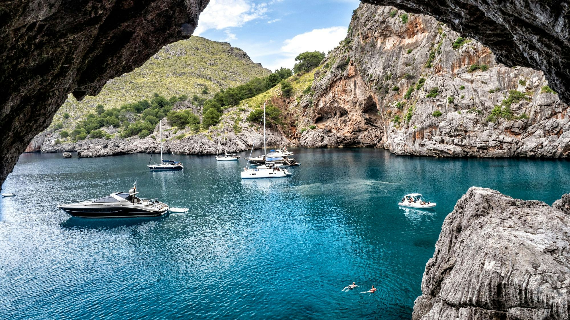 Boote liegen in einer Bucht vor der Küste Mallorcas.