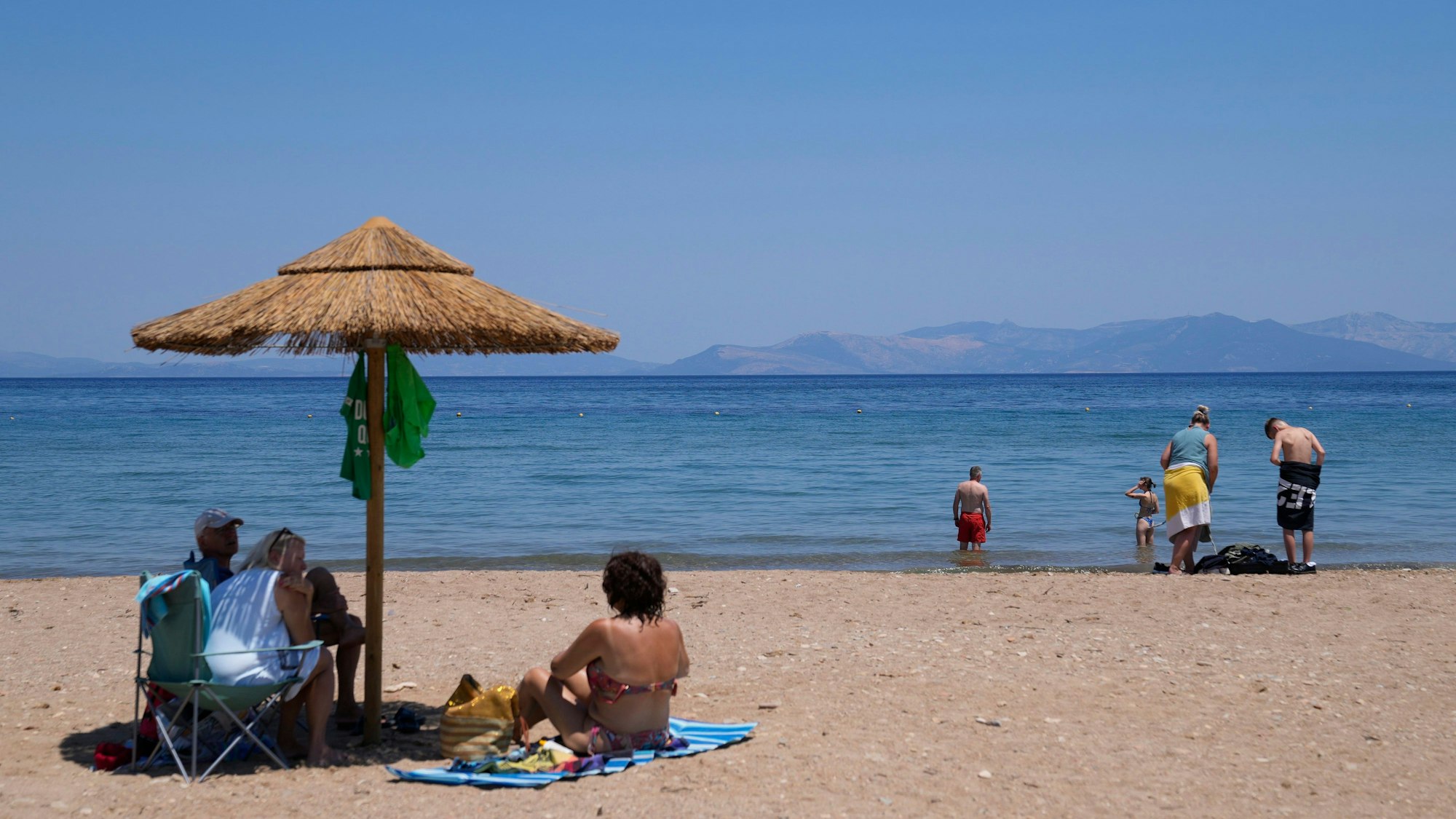 ARCHIV - 22.07.2022, Griechenland, Rafina: Menschen genießen den Tag am Meer in der Stadt Rafina, östlich von Athen.