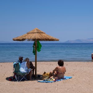 ARCHIV - 22.07.2022, Griechenland, Rafina: Menschen genießen den Tag am Meer in der Stadt Rafina, östlich von Athen.