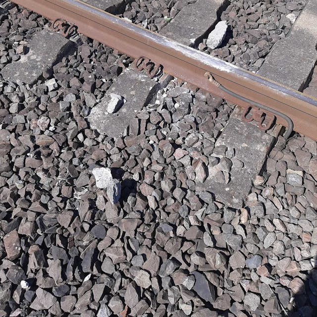 Rechts und links einer Schiene liegen die Trümmer eines Steins, der von einer S-Bahn überrollt wurde.
