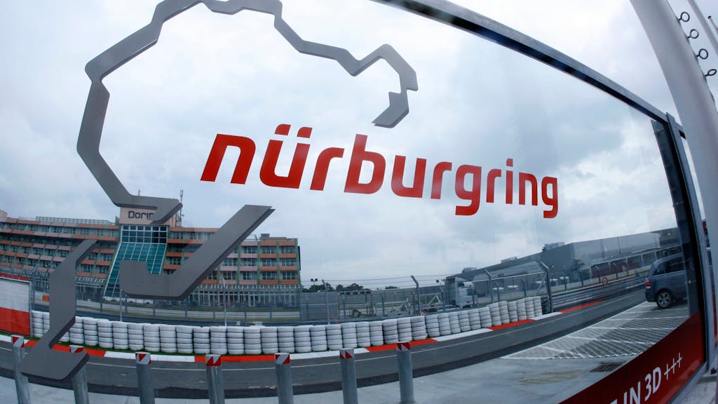 Eine Glasscheibe mit dem Logo des Nürburgrings steht an der Zufahrt zur Rennstrecke.