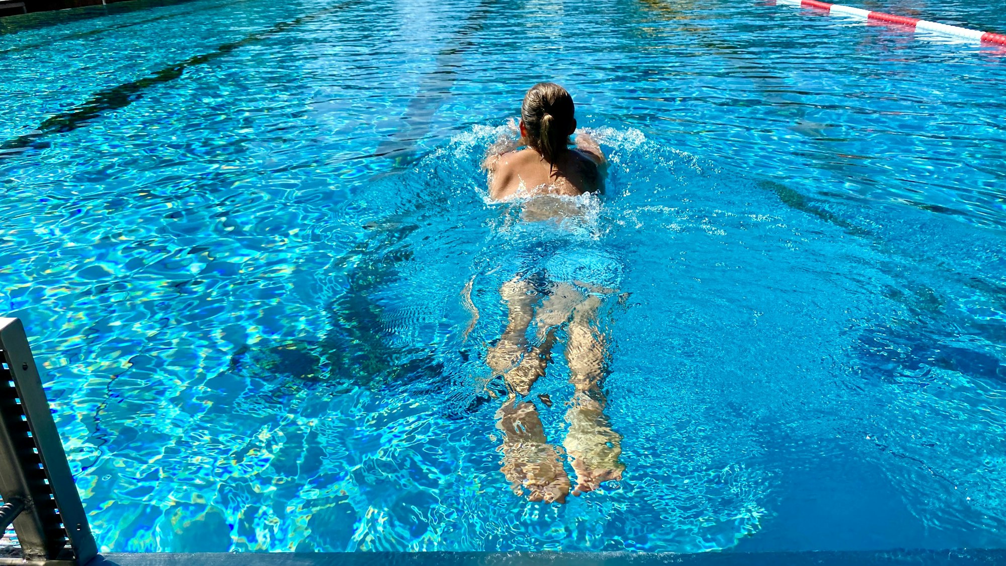Eine Frau schwimmt durch ein Becken.