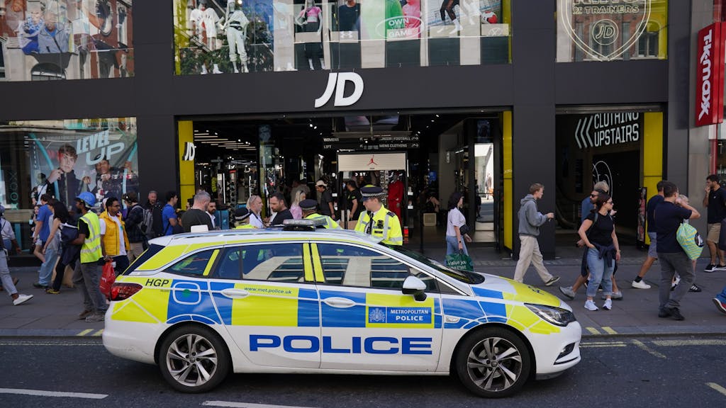 Ein Wagen der britischen Polizei sowie mehrere Beamte stehen vor dem JD Sports Geschäft auf der Oxfrod Street in London.&nbsp;