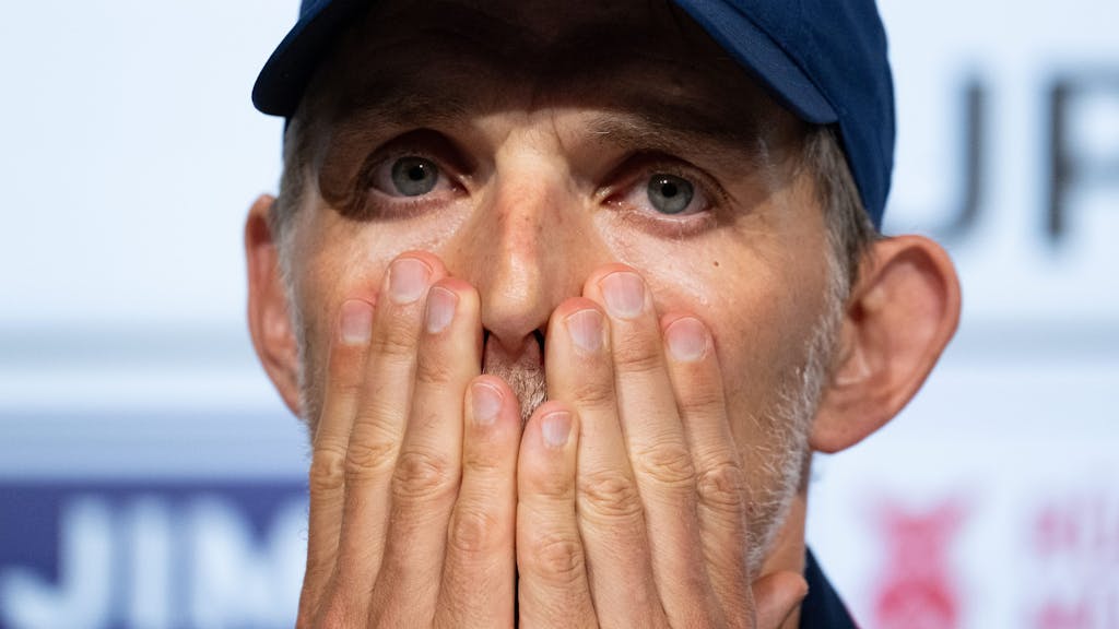 Bayern-Trainer Thomas Tuchel schlägt auf einer Pressekonferenz geschockt die Hände vors Gesicht.