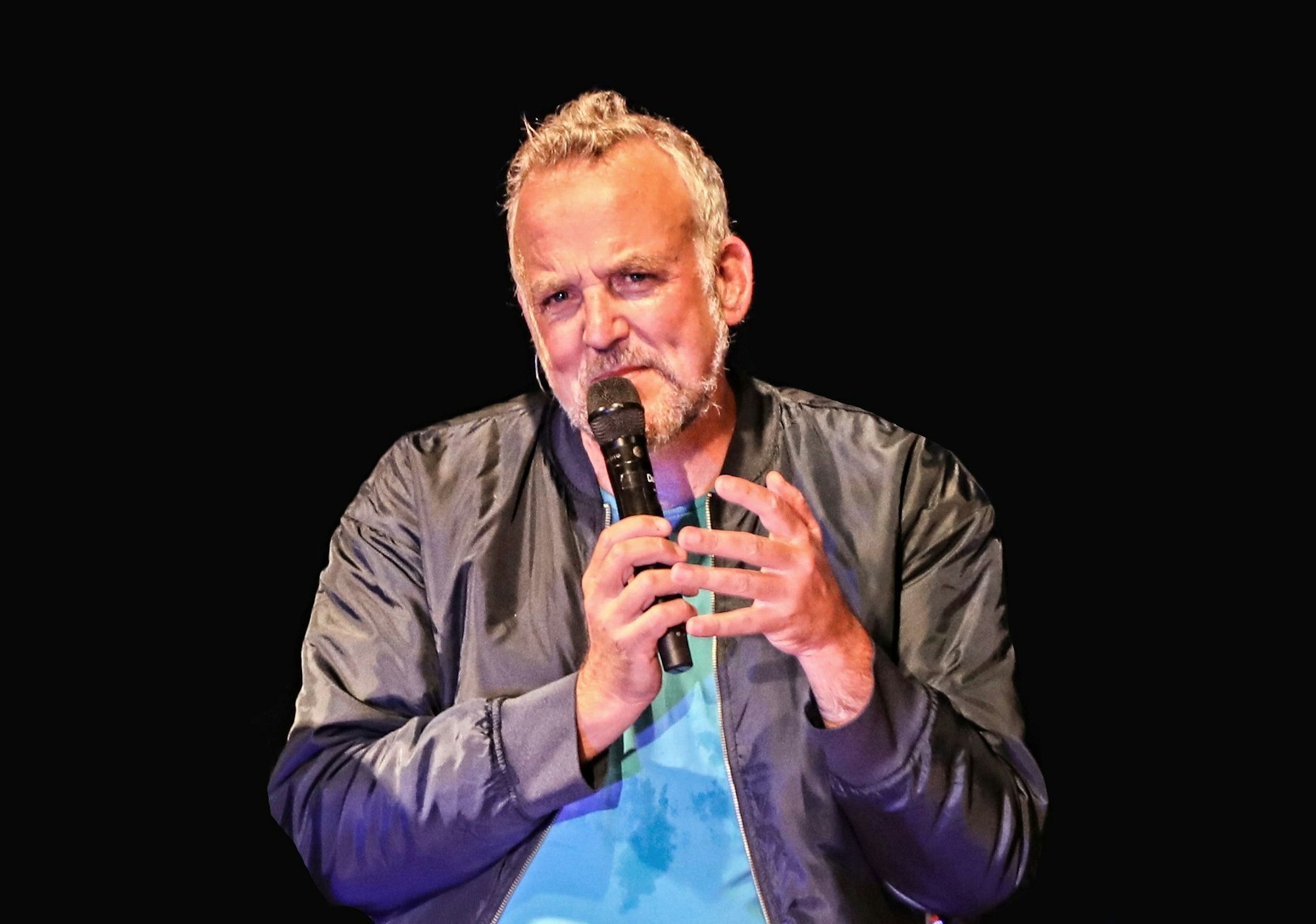 Daniel „Dän“ Dickopf hält ein Mikrofon in der Hand.