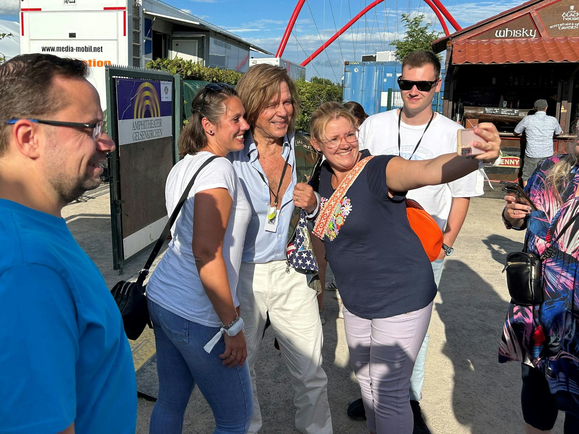 Jürgen Drews posiert mit Fans für Selfies.