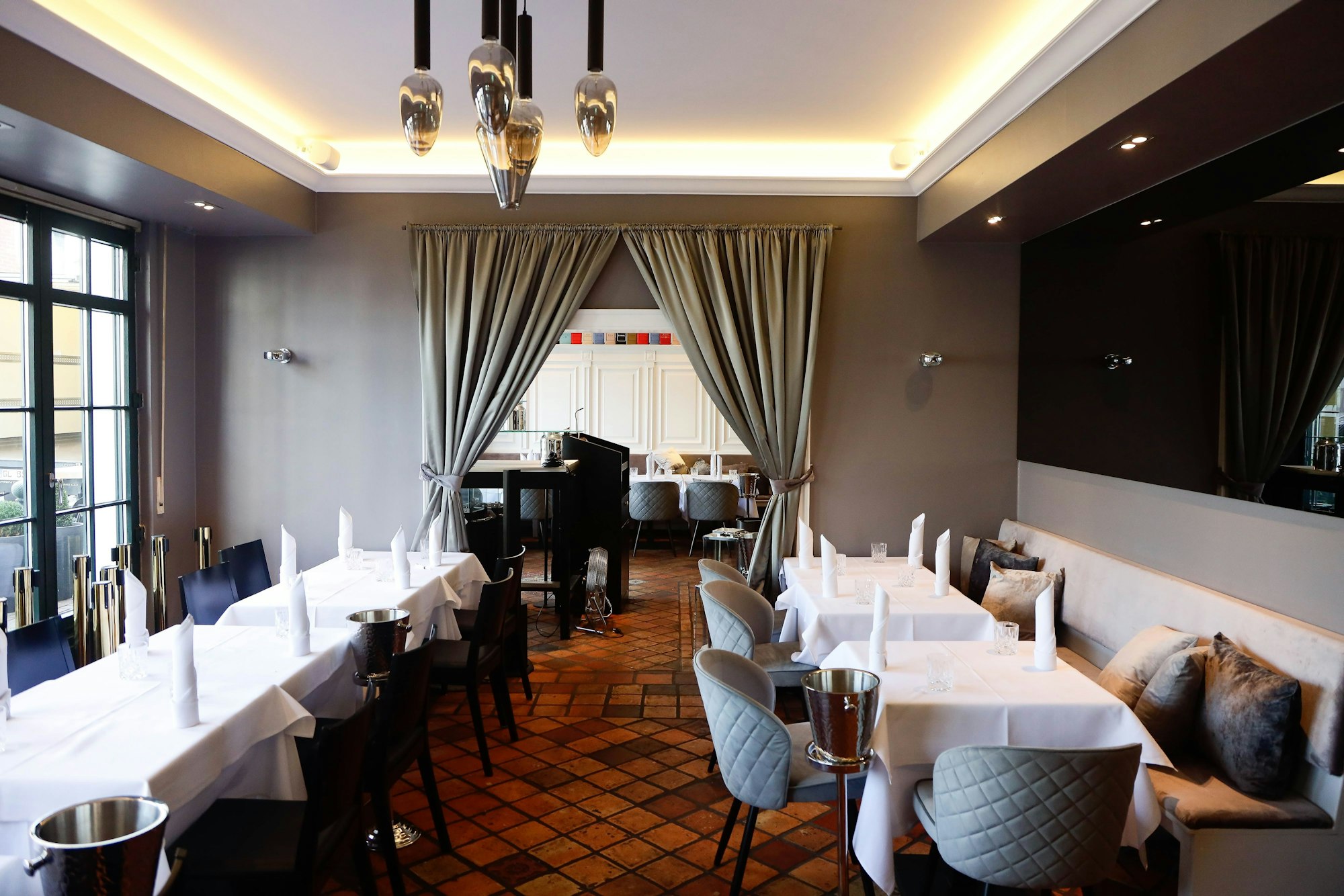 Innenansicht „Grand Culinas“, Tische mit weißen Tischdecken.
