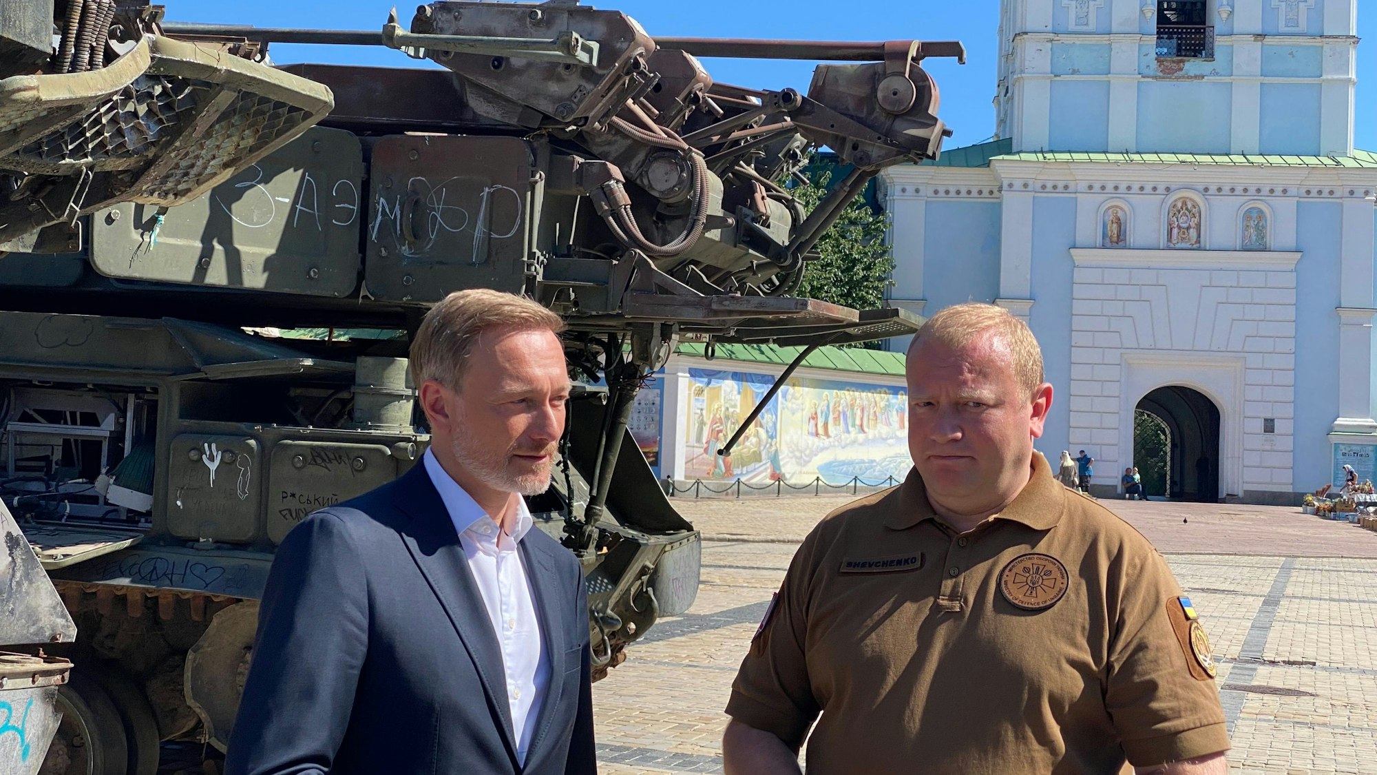 Christian Lindner (FDP, l), Bundesfinanzminister, steht in Kiew neben dem stellvertretenden Verteidigungsminister der Ukraine Andrij Schewtschenko auf dem Michaelsplatz vor erbeuteten russischen Panzern.