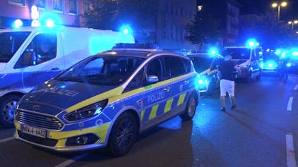Polizeifahrzeuge mit eingeschaltetem Blaulicht stehen in der Innenstadt in Essen während eines Einsatzes, hier im Juni 2023.