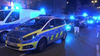 Polizeifahrzeuge mit eingeschaltetem Blaulicht stehen in der Innenstadt in Essen während eines Einsatzes, hier im Juni 2023.