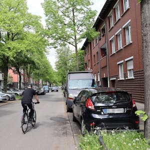 Ein Fahrradfahrer fährt zwischen Autos her.