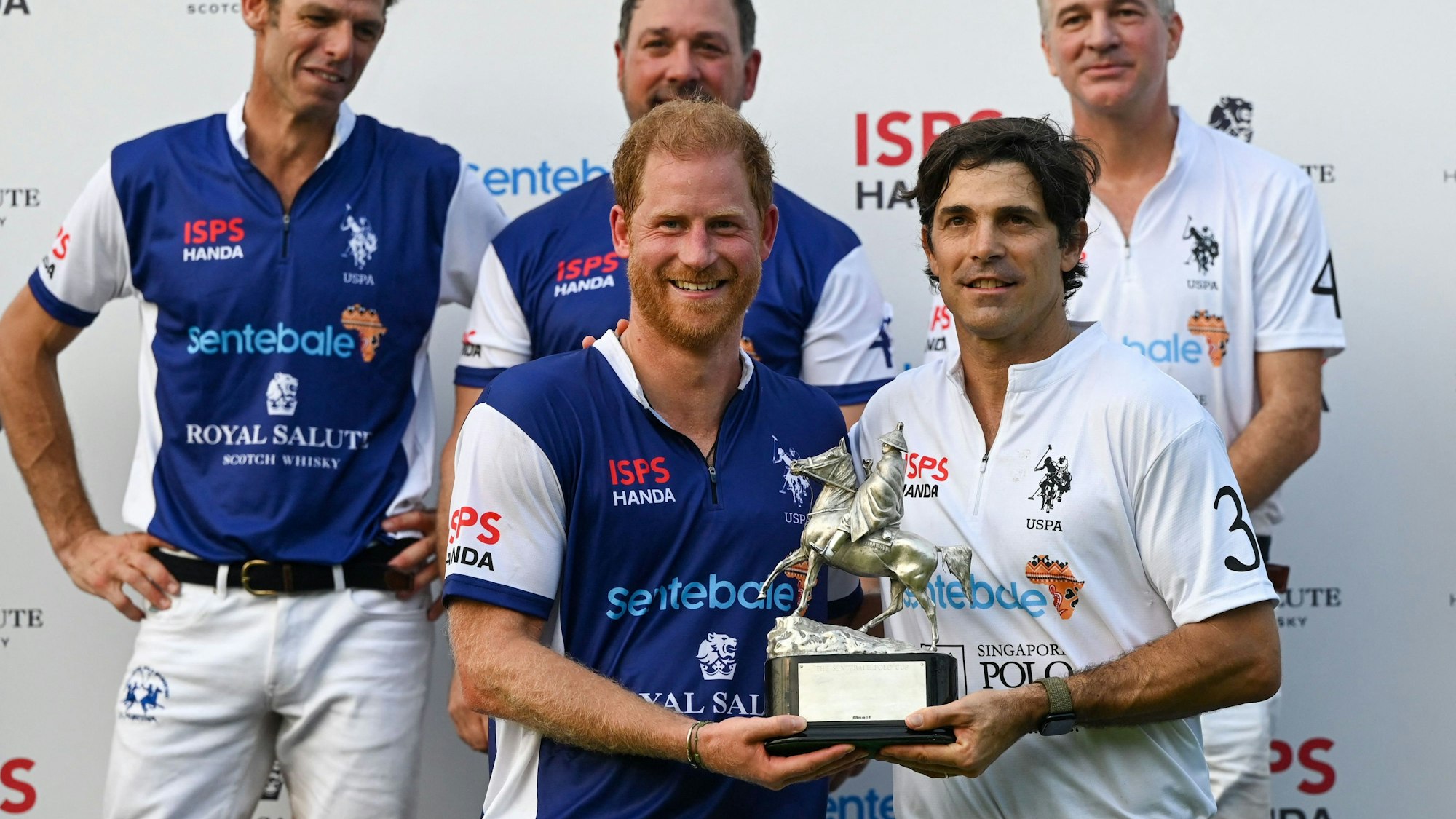 Der britische Prinz Harry und der argentinische Polospieler Nacho Figueras erhalten nach dem Sentebale ISPS Handa Polo Cup eine gemeinsame Trophäe.
