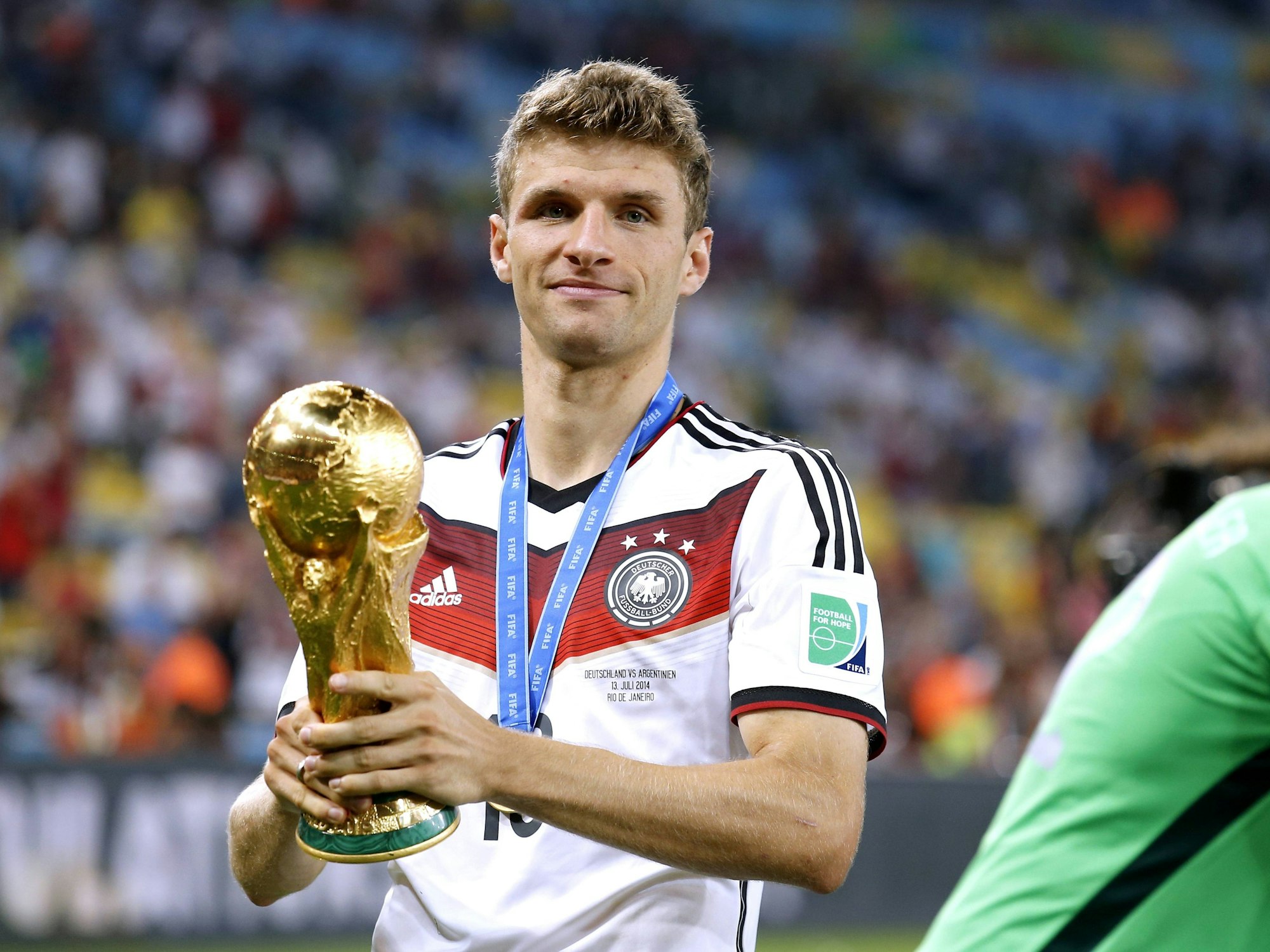 Thomas Müller 2014 mit dem WM-Pokal nach dem gewonnenen Finale. 