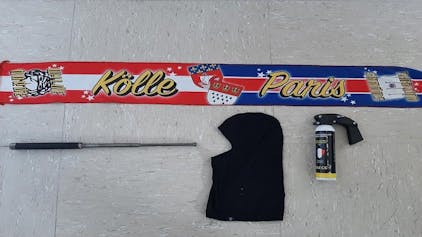 Ein Tränen-Reizstoffsprühgerät, Sturmhauben, ein Teleskopschlagstock und ein Freundschaftsschal des 1. FC Köln und Paris Saint-Germain.