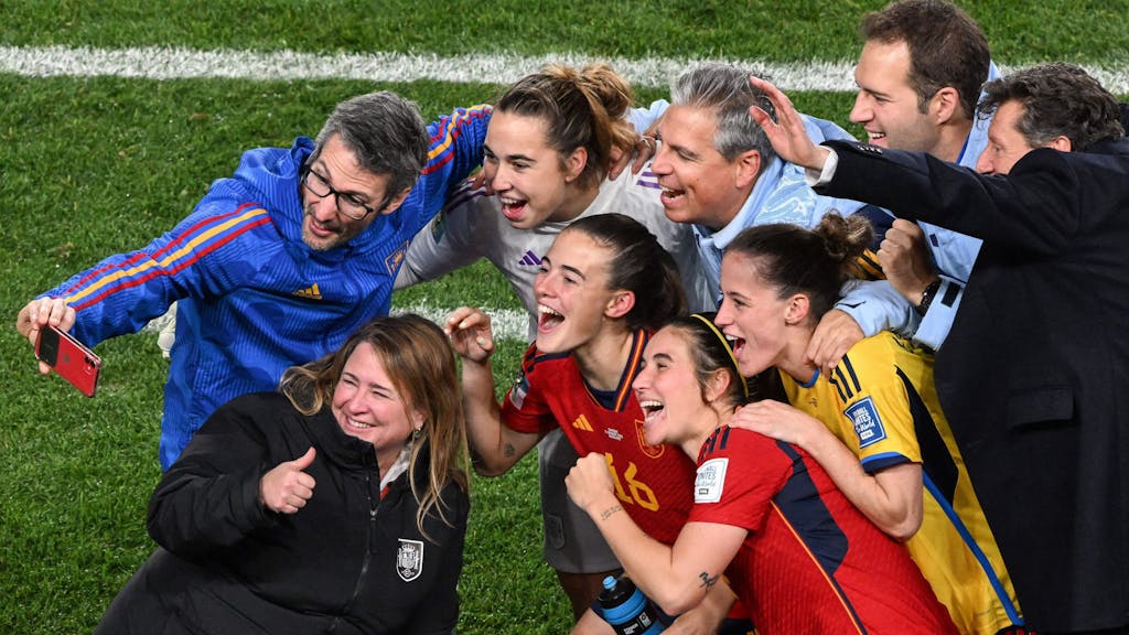 Mitglieder des spanischen Stabs posieren bei der WM 2023 mit Nationalspielerinnen.