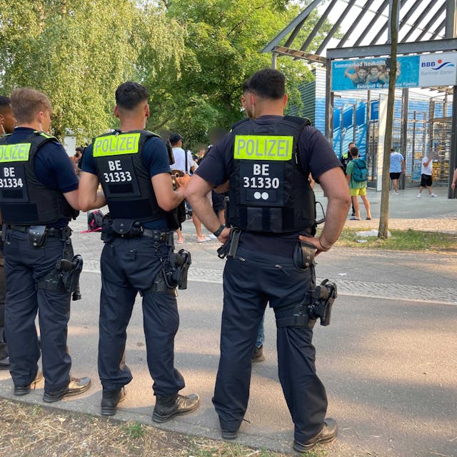 Juli 2023: Berliner Polizisten stehen vor dem Eingang des Sommerbads in Neukölln.
