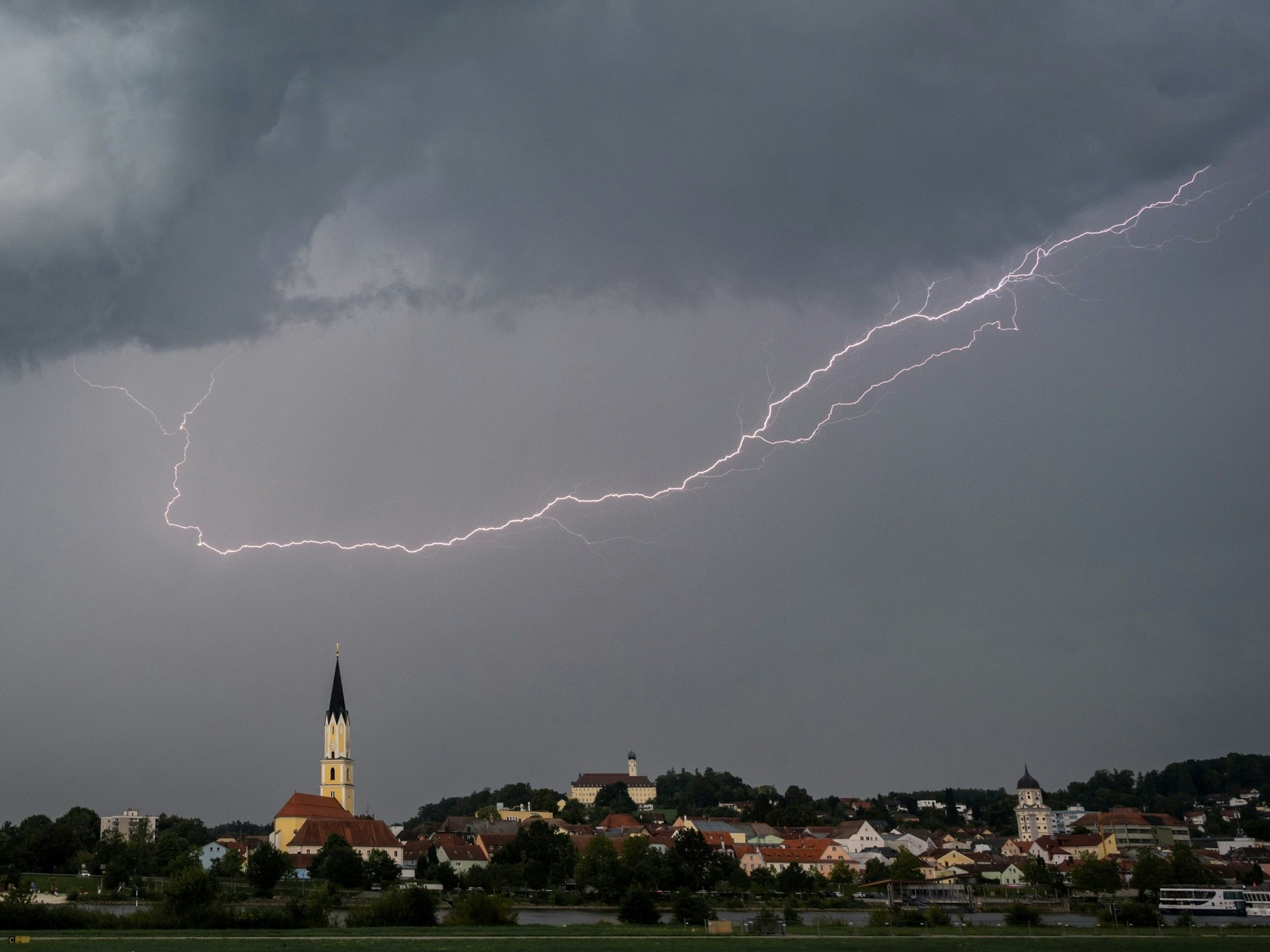 Ein Blitz leuchtet am Himmel über der Stadt Vilshofen im Landkreis Passau, hier im August 2023.