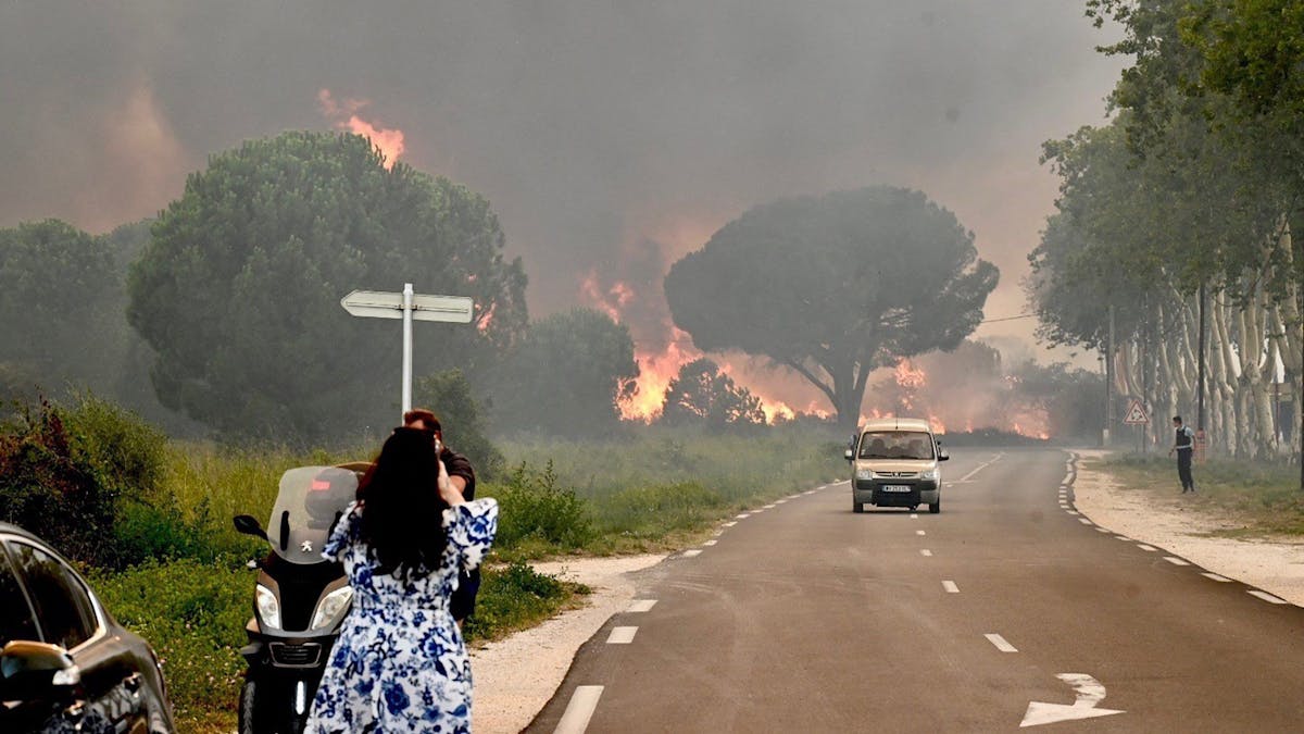 Eine Frau fotografiert in Saint-Andre in der Nähe von Argeles-sur-Mer im Südwesten Frankreichs einen Großbrand, der zur Evakuierung  von rund 3000 Touristen von nahegelegenen Campingplätzen geführt hat.