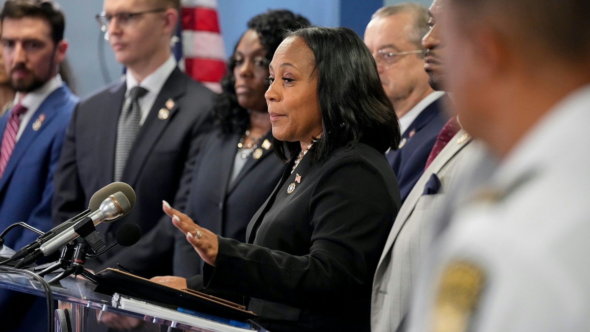 Die Bezirksstaatsanwältin Fani Willis (m.) spricht während einer Pressekonferenz. Donald Trump und mehrere Verbündete sind in Georgia angeklagt worden, weil sie versucht haben, seine Wahlniederlage von 2020 in diesem Bundesstaat zu kippen.